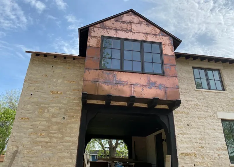 Copper metal panel facade on a stone building for Skylight Installation in Groveland