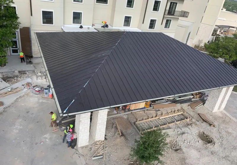 Metal roofing installation team working on a commercial building in Groveland
